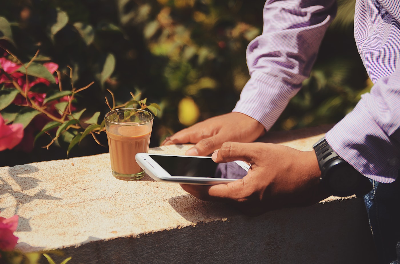 Duas pessoas à mesa de um café, uma mostrando algo no celular para a outra