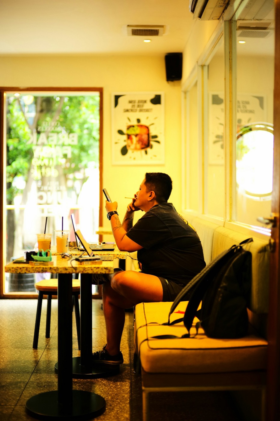 Homem sentado sozinho num café com o notebook aberto